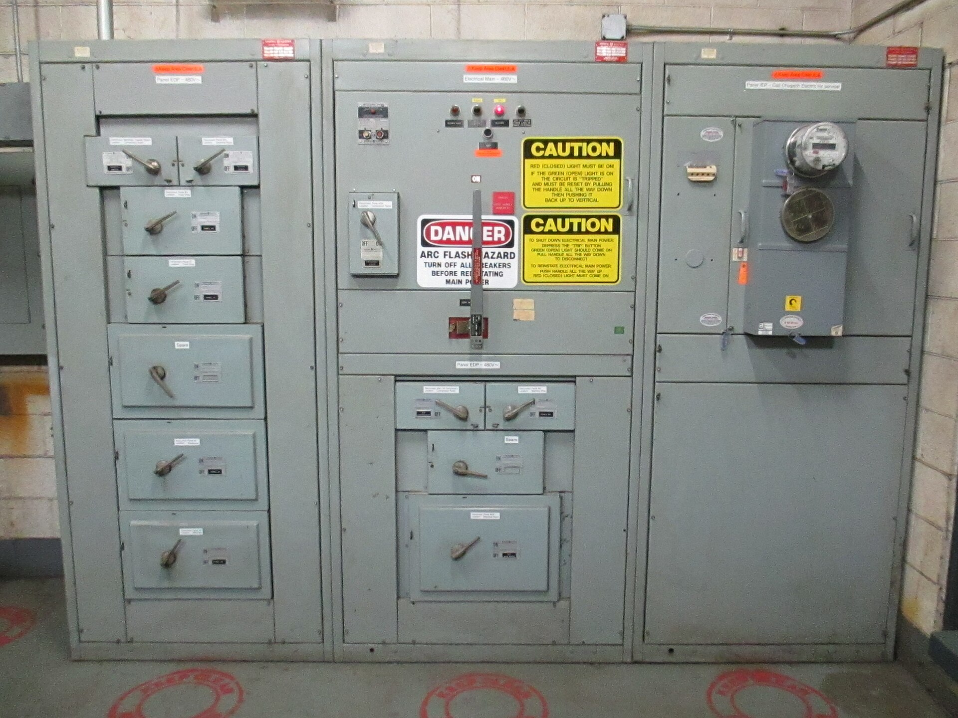Grey electrical distribution switchgear with warning labels